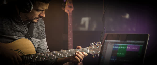 Grabando una guitarra acústica con los auriculares puestos